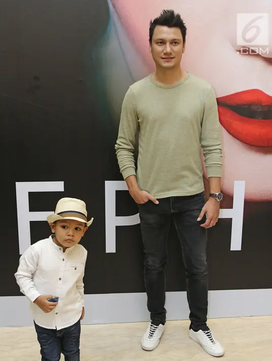 Aktor Christian Sugiono berpose bersama anaknya Arjuna Zayan Sugiono usai tampil dalam Jakarta Fashion Week 2018 di Senayan City, Jakarta, Rabu (25/10). (Liputan6.com/Herman Zakharia)