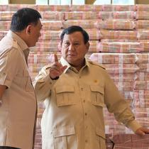 Presiden Prabowo Subianto (tengah) berbicara dengan Jaksa Agung Sanitiar Burhanuddin (kanan) dan Menteri Pertahanan Indonesia Sjafrie Sjamsoeddin di samping tumpukan uang kertas rupiah Indonesia senilai 800 juta USD di gedung Kejaksaan Agung Republik Indonesia, Jakarta, Senin 20 Oktober 2025. (BAY ISMOYO/AFP)