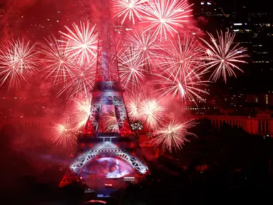 Kembang api menerangi langit di Menara Eiffel saat perayaan tradisional Hari Bastille di Paris, Prancis (14/7). Peringatan ini menandai penyerbuan penjara Bastille pada 14 Juli 1789, yang memicu revolusi Prancis. (REUTERS/Pascal Rossignol)