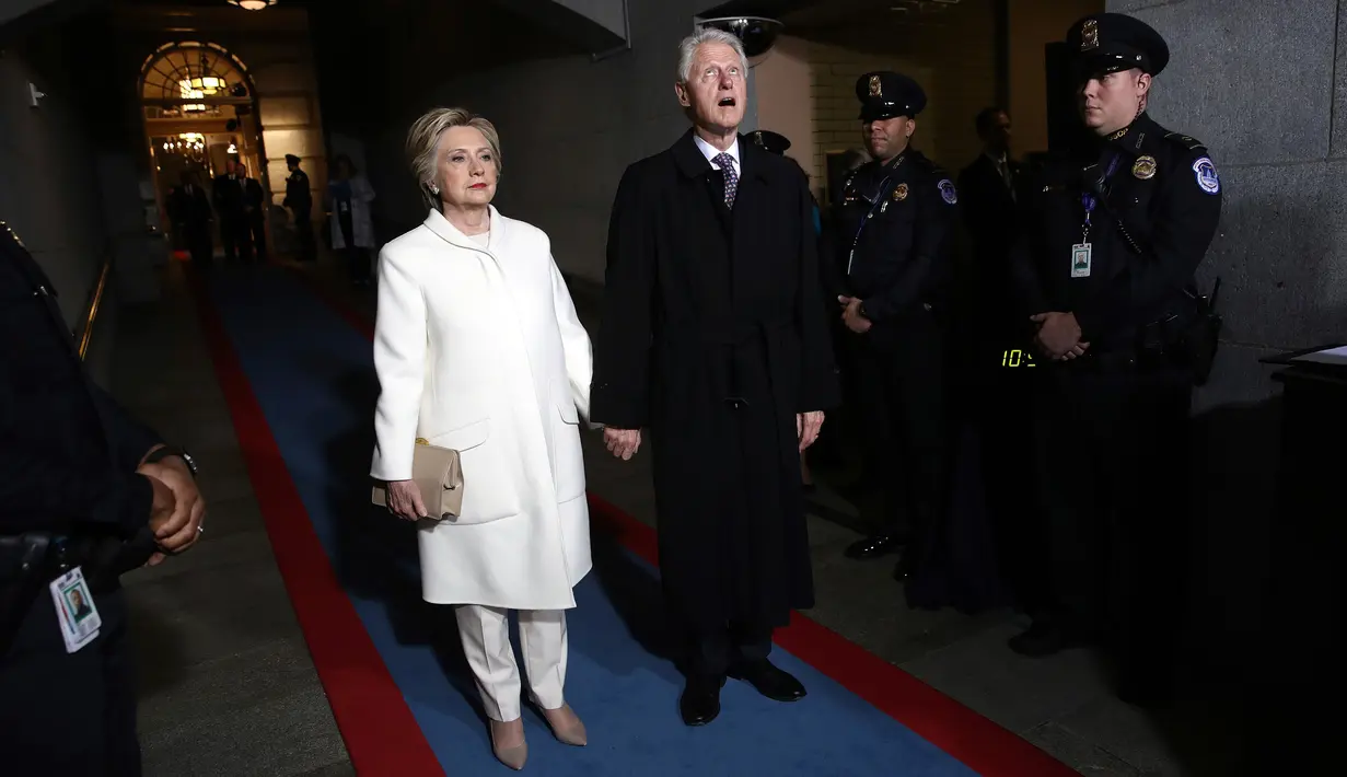 Mantan calon presiden dari partai Demokrat, Hillary Clinton dan Suaminya yang merupakan mantan Presiden AS, Bill Clinton tiba menghadiri pelantikan Donald Trump menjadi Presiden AS ke-45 di Washington, DC, AS, (20/1). (Win McNamee/Pool Photo via AP)
