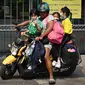 Seorang wanita menjemput anak-anaknya dari sekolah lebih awal karena polusi di Bangkok (30/1). Meningkatnya partikel berbahaya yang dikenal dengan PM 2,5 akhir Desember lalu membuat 437 sekolah di Bangkok tak beroperasi. (AFP Photo/Lillian Suwanrumpha)
