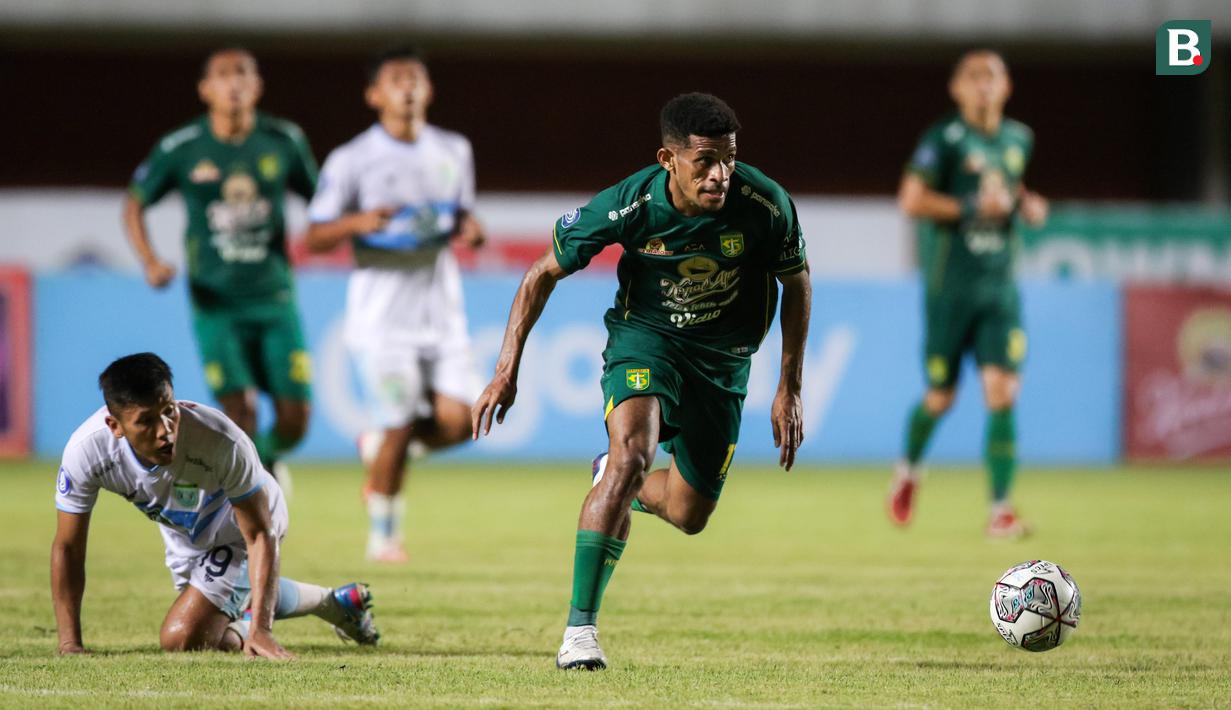 Pemain Persebaya Surabaya, Ricky Kambuaya (kanan) melewati pemain Persela Lamongan, Ahmad Bustomi dalam laga pekan ke-8 BRI Liga 1 2021/2022 di Stadion Maguwoharjo, Sleman, Kamis (21/10/2021). (Bola.com/Bagaskara Lazuardi)