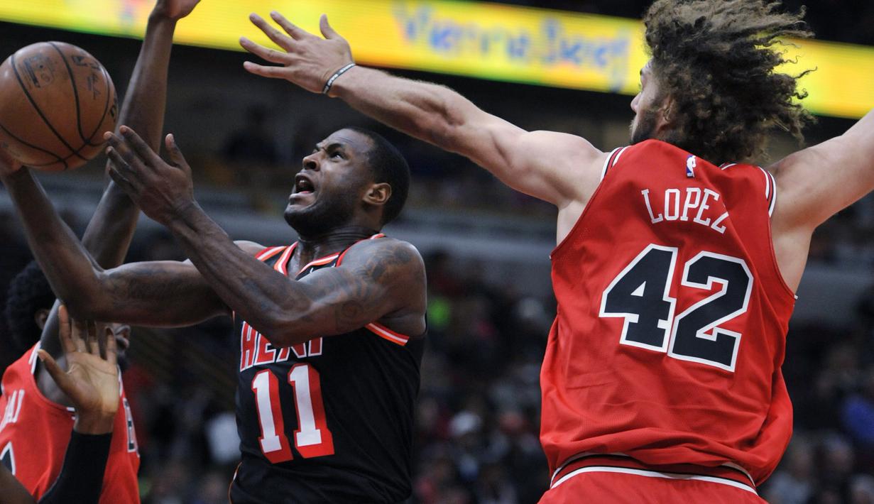 Pemain Miami Heat, Dion Waiters (tengah) melakukan tembakan saat diadang pemain Chicago Bulls, Robin Lopez (42) dan Justin Holiday (7) pada laga NBA basketball game di United Center, Chicago, (26/11/2017). Miami Heat menang 100-93.  (AP/Paul Beaty)