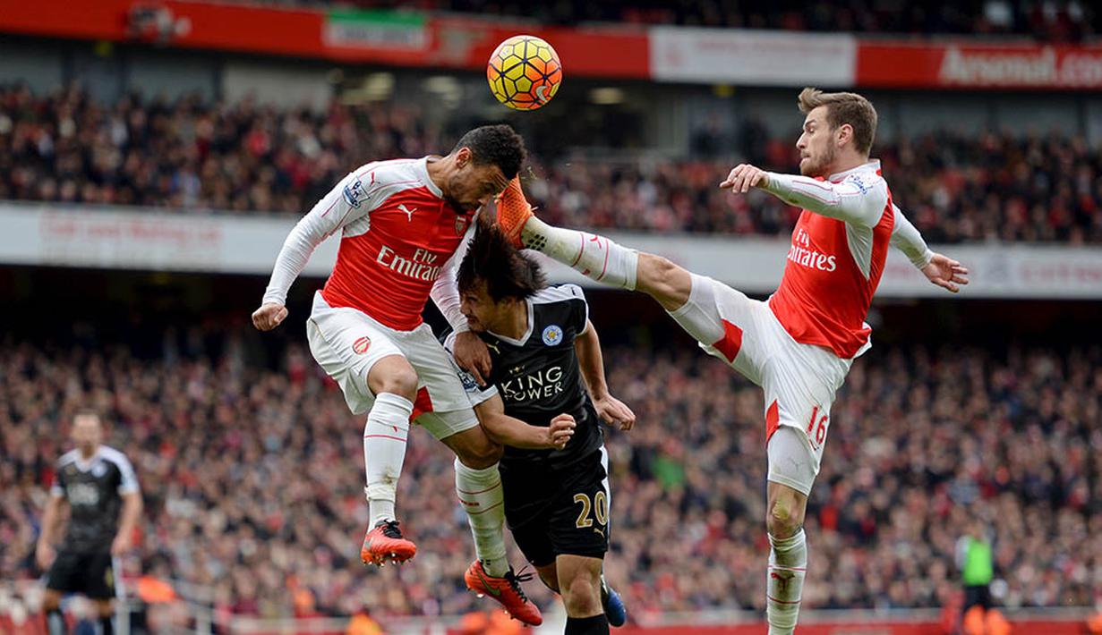 Kaki gelandang Arsenal, Aaron Ramsey, terangkat tinggi mengenai kepala gelandang Leicester, Shinji Okazaki, pada laga Liga Inggris di Stadion Emirates, Inggris, Minggu (14/2/2016). Arsenal berhasil menaklukan Leicester 2-1. (Reuters/Tony O'Brien)