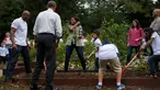 Ibu negara AS Michelle Obama didampingi Presiden AS, Barack Obama dan mantan pebasket Alonzo Mourning, Jr saat memanen ubi jalar di kebun Gedung Putih, Washington, (6/10). (AFP Photo/Jim Watson)