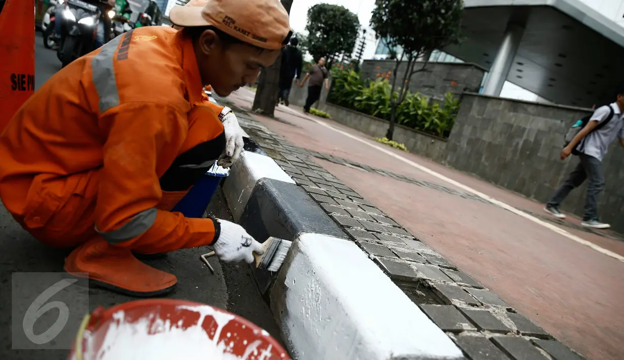 Petugas dari Kelurahan Karet Semanggi mengecat trotoar di kawasan Jalan Semanggi, Jakarta, Selasa (1/3/2016). Trotoar itu dipercantik dengan dicat ulang oleh Petugas Prasarana Sarana Umum (PPSU). (Liputan6.com/Faizal Fanani)