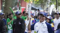 Legenda tinju Indonesia, Ellyas Pical membawa obor saat Torch Relay Asian Games 2018 di Kota Bogor, Jawa Barat, Selasa (14/8/2018). (Bola.com/Reza Bachtiar)