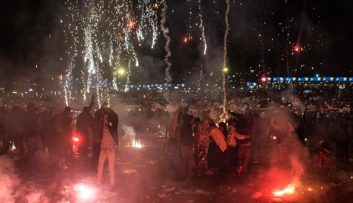 Kembang api mewarnai pelepasan balon udara yang membawa lentera kecil selama Festival Tazaungdaing di Taunggyi, Myanmar pada 14 November 2018. Festival tahunan itu diselenggarakan guna merayakan berakhirnya musim hujan. (Ye Aung THU / AFP)