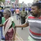 Seorang wanita tua dibantu menyelamatkan diri pasca-ledakan di St. Anthony, Sri Lanka ( Eranga Jayawardena / AP )