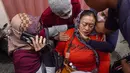 Seorang wanita menangis setelah menerima konfirmasi bahwa anggota keluarganya termasuk dalam korban tewas pada kerusuhan Stadion Kanjuruhan di Rumah Sakit Saiful Anwar, Malang, Jawa Timur, Minggu (2/10/2022). Dari 129 korban tewas, dua di antaranya adalah polisi. (AP Photo/Trisnadi)