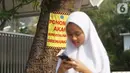 Poster revitalisasi menempel pada pohon yang berada di jalur pedestrian Jalan Kramat Raya, Jakarta, Jumat (8/11/2019). Sepanjang pengerjaan jalur pedestrian, pohon yang berada di jalur tersebut rencananya juga akan direvitalisasi dan diremajakan. (Liputan6.com/Immanuel Antonius)