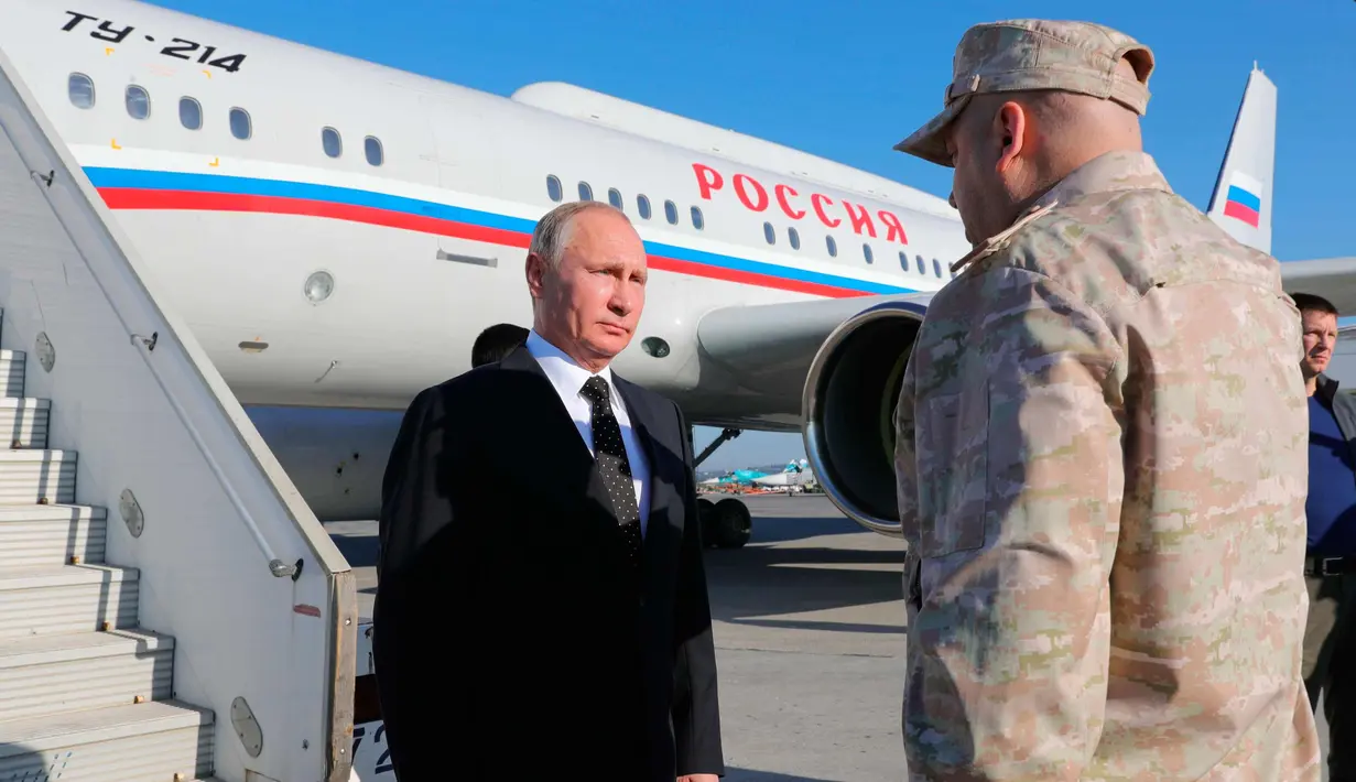 Presiden Rusia, Vladimir Putin tiba di pangkalan udara Hemeimeem di Suriah (11/12). Putin berhenti di pangkalan udara Hemeimeem di Provinsi pesisir Latakia di Suriah saat perjalanan menuju Mesir. (Mikhail Klimentyev, Sputnik, Kremlin Pool Photo via AP)
