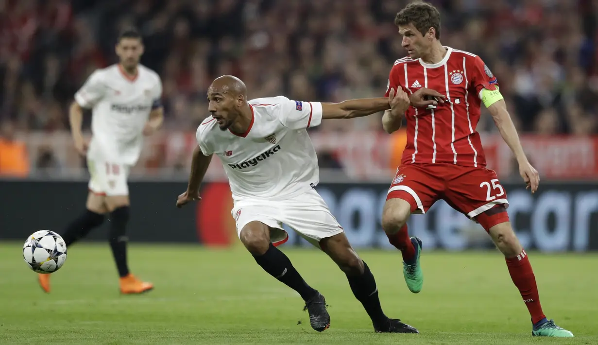 Pemain Sevilla, Steven N'Zonzi (kiri) mencoba melewati adangan pemain Bayern, Thomas Mueller pada leg kedua perempat final Liga Champions di Allianz Arena stadium, Munich, (11/4/2018). Bayern lolos ke semifinal dengan agregat 2-1. (AP/Matthias Schrader)