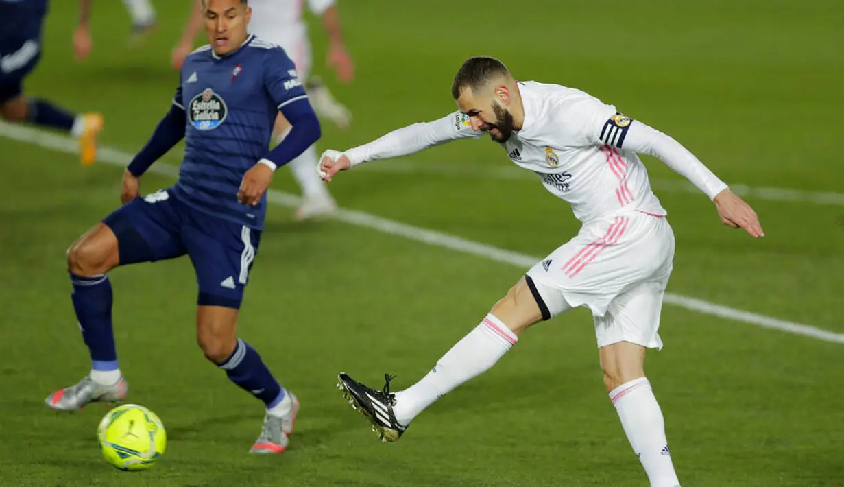 Striker Real Madrid, Karim Benzema, melepaskan tendangan saat melawan Celta Vigo pada laga Liga Spanyol di Stadion Alfredo Di Stefano, Sabtu (2/1/2021). Real Madrid menang dengan skor 2-0. (AP/Manu Fernandez)