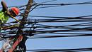 Petugas PLN mengecek instalasi kabel di tiang listrik milik PLN, Jakarta (26/2). Mulai 28 Februari 2016, PLN berencana membongkar perangkat atau jaringan telematika yang memanfaatkan tiang listrik di Jakarta tanpa izin. (Liputan6.com/Immanuel Antonius)