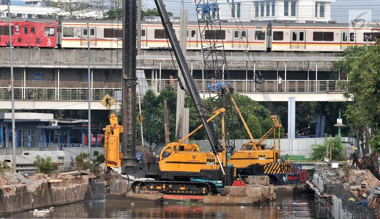Kereta melintas saat petugas Dinas Sumber Daya Air Pemprov DKI Jakarta membangun turap di Kali Ciliwung Lama, Jakarta, Kamis (11/10). Berdasar kajian, 129 kelurahan berpotensi terendam banjir akibat normalisasi tidak berjalan. (Merdeka.com/Iqbal Nugroho)
