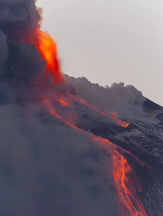 lahar panas menyembur dari Gunung Etna dekat Catania, Sisilia, Italia, Selasa (16/2/2021). Gunung Etna merupakan gunung berapi tertinggi dan teraktif di Eropa. AP Photo/Salvatore Allegra)