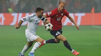 Pemain LOSC Lille, Mitchel Bakker (kanan) berebut bola dengan pemain Real Madrid, Dani Carvajal pada laga Liga Champions yang berlangsung di Pierre-Mauroy Stadium, Villeneuve d'Ascq, Prancis, 2 October 2024. (AFP/Francois Lo Presti)