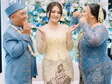 Nathalie Holscher tampil anggun dalam balutan kebaya berwarna kuning. Wanita 31 tahun itu berdiri dengan senyum menawan di antara pasangan pengantin yang mengenakan busana serba biru. Kebaya karya desainer Dea Febrinda itu semakin cantik dipadukan dengan bawahan batik bernuansa krem. (Liputan6.com/IG/@nadyaholscher)