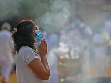 Seorang umat Buddha berdoa selama festival Waisak di Kuil Kelaniya di Kolombo, Sri Lanka, Minggu (15/5/2022). Pihak berwenang Sri Lanka mencabut jam malam nasional pada 15 Mei ketika negara pulau yang kekurangan uang tersebut bersiap untuk merayakan festival Buddha yang penting, dengan perayaan yang diredam oleh krisis keuangan yang semakin memburuk. (Ishara S. KODIKARA / AFP)