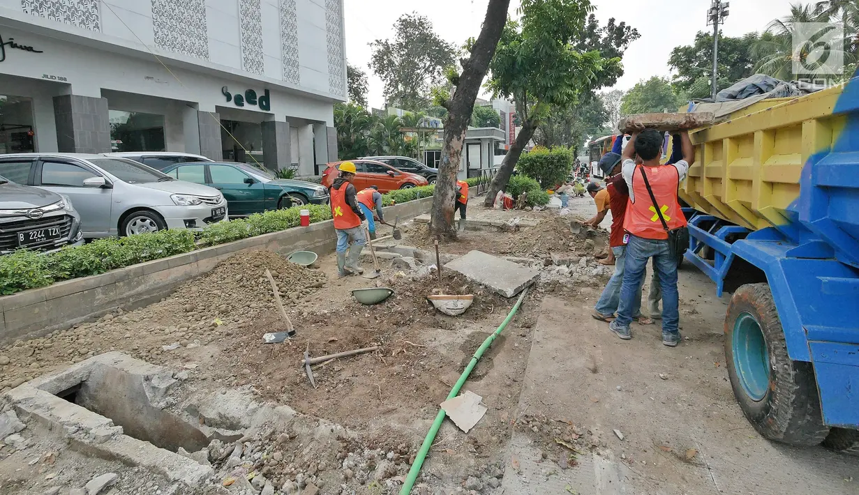 Pekerja menyelesaikan proyek revitalisasi trotoar di kawasan Kemang, Jakarta, Jumat (29/6/2019). Revitalisasi trotoar Kemang diharapkan dapat membuat ekonomi di kawasan tersebut menjadi lebih baik. (Liputan6.com/Herman Zakharia)