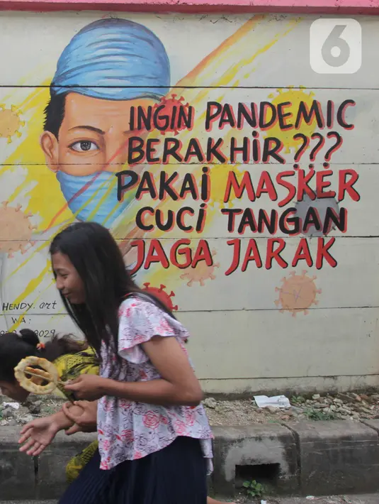 Warga melintasi mural bertema covid-19 di Tanah Tinggi, Tangerang, Sabtu (29/1/2022). Kasus Covid-19 varian Omicron di Indonesia terus bertambah dan wilayah penyebarannya semakin meluas. Diperkirakan, kasus omicron sudah mendominasi penularan virus corona di Jawa Bali. (Liputan6.com/Angga Yuniar)