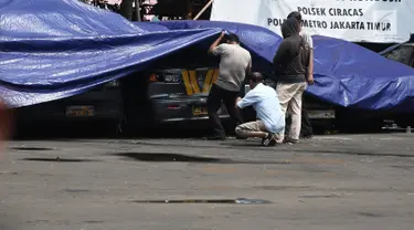 Petugas melihat melihat kondisi mobil yang dirusak di Polsek Ciracas, Jakarta, Rabu (12/12). Mobil yang dirusak di antaranya mobil polisi dan mobil Puspom Kodam. (Liputan6.com/Herman Zakharia)