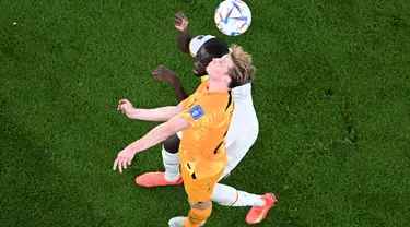 Gelandang Senegal #08 Cheikhou Kouyate (atas) berebut bola dengan gelandang Belanda #21 Frenkie De Jong selama pertandingan pada pertandingan kedua Grup A Piala Dunia 2022 di Stadion Al-Thumama di Doha, Senin (21/11/2022). Cheikhou Kouyate tak bisa melanjutkan laga Timnas Senegal vs Timnas Belanda hingga rampung. (Kirill KUDRYAVTSEV / AFP)