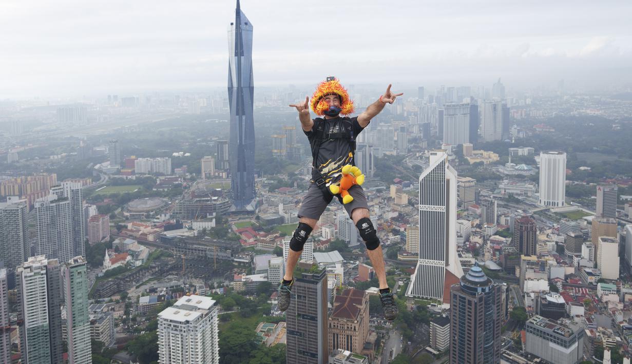 Seorang pelompat BASE terjun dari Menara Kuala Lumpur selama KL Tower International Jump Malaysia di Kuala Lumpur, Jumat (3/2/2023). Event wisata olahraga ini mengajak traveler penantang adrenalin untuk base jump, semacam terjun bebas, dari sisi atas menara di ketinggian sekitar 300 meter. (AP Photo/Vincent Thian)