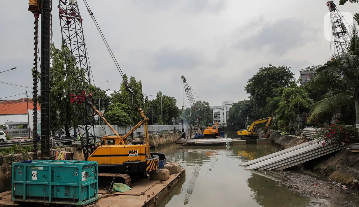 Pekerja menyelesaikan pemasangan dinding turap di kali pasar baru, Jakarta, Rabu (9/3/2022). Dinas Sumber Daya Air DKI Jakarta melakukan pemasangan turap bertujuan untuk mengantisipasi banjir serta tanah ambles di pinggir sungai. (Liputan6.com/Faizal Fanani)