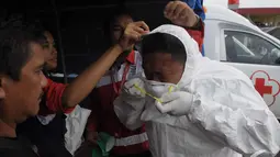 Tim menggunakan masker guna membawa jenazah korban kecelakaan pesawat QZ8501 yang tiba dari KRI Banda Aceh untuk dipindahkan ke RS Sultan Imanuddin di Lanud Iskandar Pangkalan Bun, Kalteng, Rabu (7/1/2015). (Liputan6.com/Andrian M Tunay)