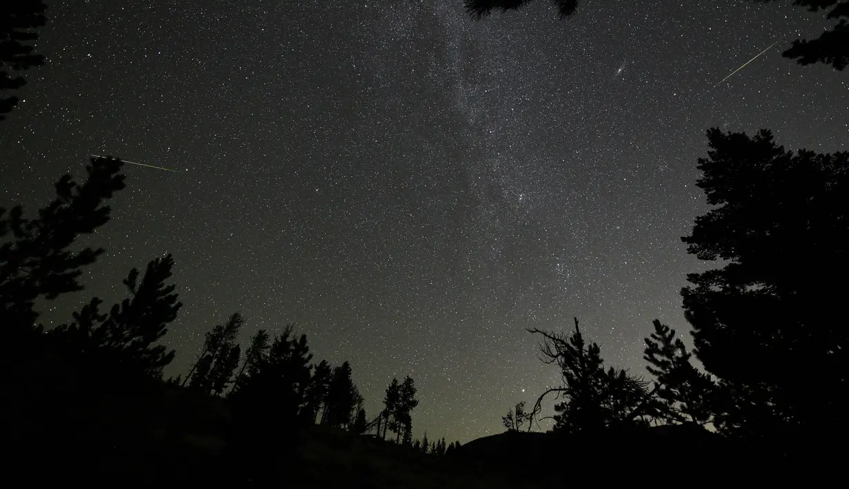 Sebuah meteor Perseid (kanan) terlihat di dekat Andromeda Galaxydi Taman Nasional Rocky Mountain, Colorado, Minggu (12/8). Peristiwa hujan meteor Perseid mengalami puncaknya akhir pekan ini pada 11-12 Agustus dan 12-13 Agustus. (AFP / STAN HONDA)
