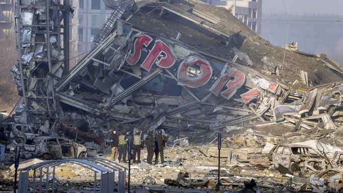 Orang-orang memeriksa kerusakan setelah serangan sebuah pusat perbelanjaan di Kiev, Ukraina, Senin (21/3/2022). Delapan orang tewas dalam serangan tersebut. (AP Photo/Efrem Lukatsky)