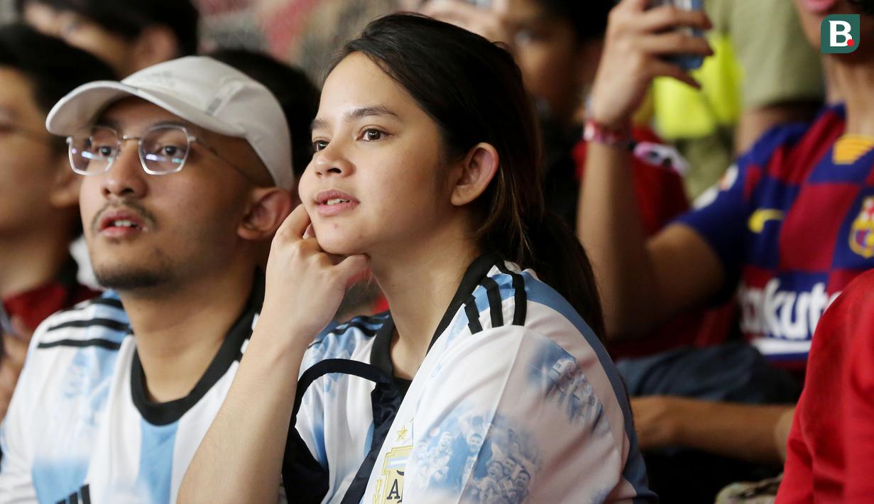 Suporter wanita berjersey Argentina tampak menikmati pertandingan antara Timnas Indonesia vs Argentina pada laga FIFA Matchday 2023 di Stadion Utama Gelora Bung Karno, Jakarta, Senin (19/6/2023). (Bola.com/Muhammad Iqbal Ichsan)
