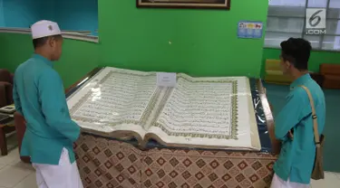 Pengunjung mengamati Alquran raksasa yang dipajang di perpustakaan Jakarta Islamic Centre, Jakarta Utara, Jumat (18/5). Alquran yang ditulis tangan tersebut sudah berusia 16 tahun. (Liputan6.com/Arya Manggala)