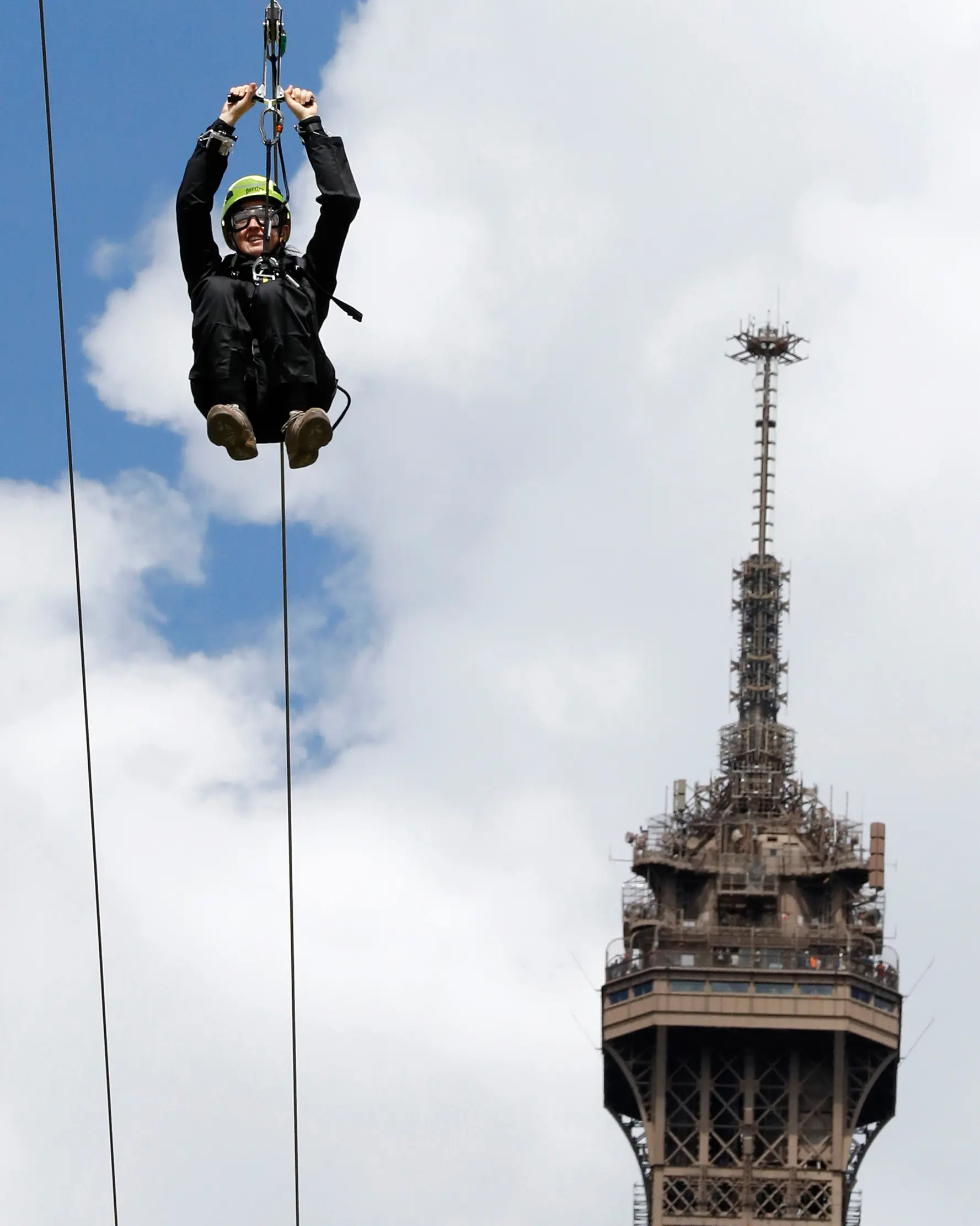Seorang pengunjung meluncur dari Menara Eiffel di Paris dengan menggunakan peralatan flying fox, 5 Mei 2017. Kesempatan ini dibuka untuk umum jelang turnamen tenis French Open agar dapat merasakan bagaimana kecepatan bola tenis (FRANCOIS GUILLOT/AFP)