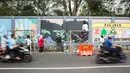 Seniman menyelesaikan pembuatan mural di kawasan Ragunan, Jakarta, Kamis (29/9/2022). Mural yang dibuat menampilkan karakter flora, fauna, dan landmark Jakarta. (Liputan6.com/Faizal Fanani)