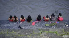 Sejumlah wanita Hindu Nepal mandi suci di sungai Bagmati selama festival Rishi Panchami di Kathmandu (3/9/2019). Di festival ini para wanita berpuasa di siang hari dan berdoa untuk umur panjang untuk suami mereka. (AFP Photo/Prakash Mathema)