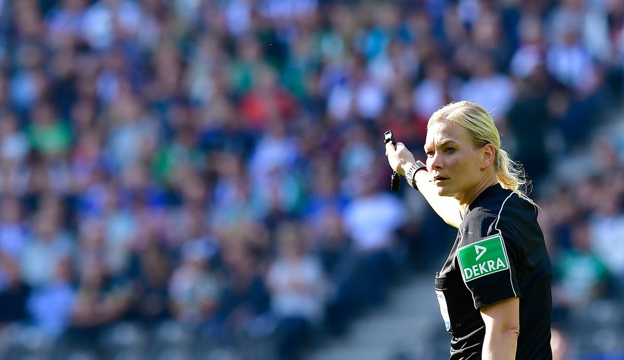 Wasit wanita, Bibiana Steinhaus saat membikan keputusan pada laga Bundesliga antara Hertha Berlin dan Werder Bremen di Berlin, Jerman (10/9/2017). Laga tersebut merupakan debut Bibiana Steinhaus. (AFP/Tobias Schwarz)