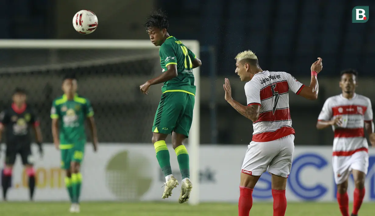 Striker Persebaya Surabaya, Mochammad Supriadi (kiri) menyundul bola di depan bek Madura United, Jaimerson Xavier dalam laga matchday ke-2 Grup C Piala Menpora 2021 di Stadion Si Jalak Harupat, Bandung, Minggu (28/3/2021). (Bola.com/M Iqbal Ichsan)