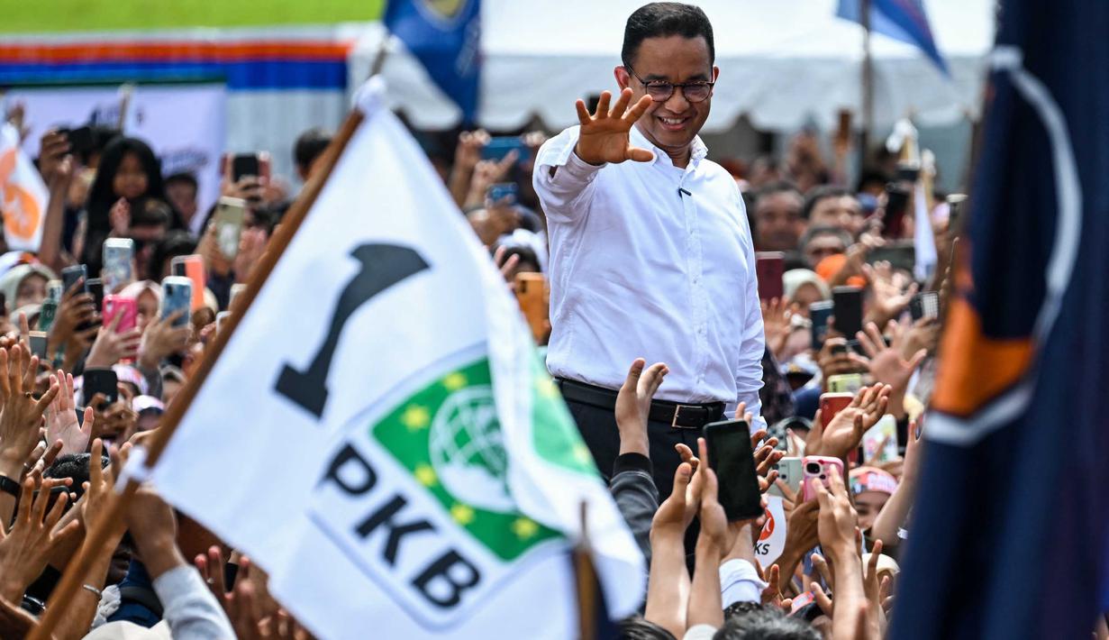 Menggunakan kemeja putih, Anies Baswedan mendatangi dan menyalami para pendukungnya. (CHAIDEER MAHYUDDIN/AFP)