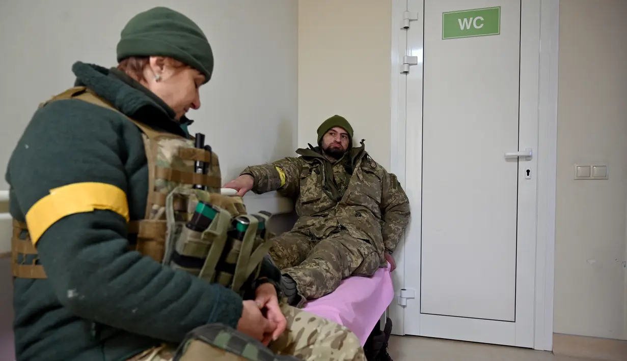 Seorang prajurit Ukraina yang terluka ringan (kanan) beristirahat di klinik bersalin swasta Leleka ('Stork') yang tidak jauh dari desa garis depan Horenka, Kiev pada 10 Maret 2022. Klinik tersebut menjadi stasiun bantuan garis depan untuk tentara dan warga sipil yang terluka. (Sergei SUPINSKY/AFP)