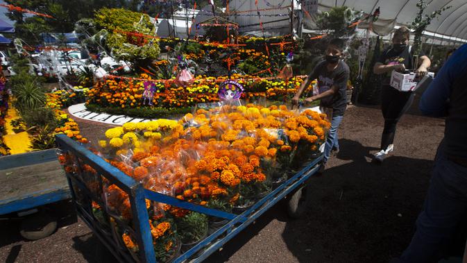 Orang-orang berbelanja bunga marigold di Xochimilco, Mexico City, Meksiko, Rabu (14/10/2020). Panen bunga marigold Meksiko yang dikenal sebagai Cempasuchil dalam bahasa Nahuatl dilakukan jauh-jauh hari sebelum hari libur Day of the Dead. (AP Photo/Marco Ugarte)