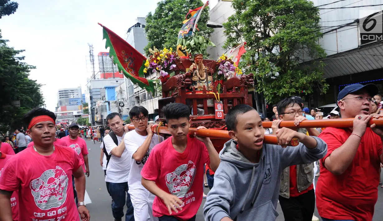 Warga memanggul patung dewa saat karnaval Cap Go Meh 2018 di Jalan Gajah Mada, Jakarta, Minggu (4/3). Beragam atraksi budaya ditampilkan dalam karnaval perayaan Cap Go Meh 2018 di kawasan Glodok Jakarta. (Liputan6.com/Helmi Fithriansyah)