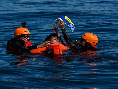 Anggota Badan Pencarian dan Pertolongan Nasional (Basarnas) menyelamatkan seorang relawan saat latihan bersama di perairan lepas pantai Banda Aceh pada 31 Agustus 2024. (CHAIDEER MAHYUDDIN/AFP)