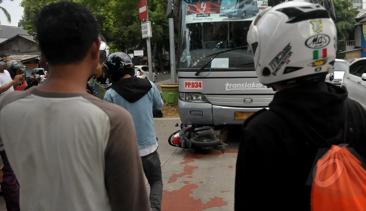 Sejumlah warga menyaksikan evakuasi sepeda motor yang tertabrak Bus Transjakarta di kawasan permata hijau, Jakarta, Jumat (27/3/2015). Sejumlah warga sedang melakukan evakuasi speda motor yang berada di dalam bus transjakarta. (Liputan6.com/Johan Tallo)