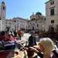 Wisatawan duduk di teras Stradun, jalan utama kota tua Dubrovnik pada 28 Maret 2019. Tahun lalu lebih dari 1,2 juta turis mengunjungi Dubrovnik, kota yang paling banyak dikunjungi di Kroasia. (Denis LOVROVIC / AFP)