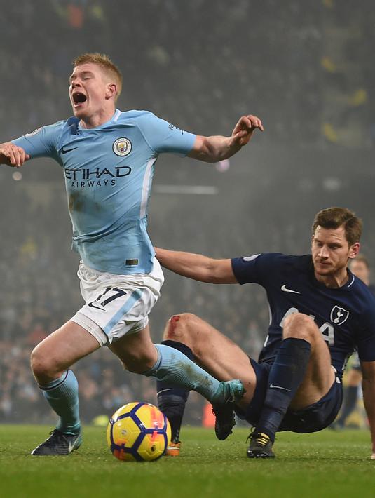 Pemain Manchester City, Kevin De Bruyne (kiri) jatuh saat diadang pemain Tottenham Hotspur,  Jan Vertonghen pada lanjutan Premier League di Etihad Stadium, Manchester, (16/12/2017). Manchester City menang 4-1. (AFP/Paul Ellis)