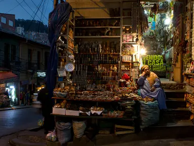 Seorang wanita duduk di toko jimat andalan penganut Pachamama di Pasar Penyihir, kota tua La Paz, Bolivia, 10 Juli 2018. Pasar bernama Mercado de las Brujas ini menjual barang-barang aneh dan segala sesuatu yang berhubungan dengan sihir. (AP/Juan Karita)