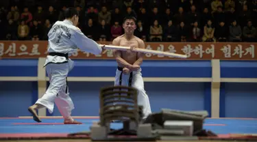 Seorang peserta saat dipukul dengan kayu selama demonstrasi taekwondo sebagai bagian dari Kejuaraan Seni Bela Diri Nasional tahunan Mangyongdae di 'Taekwon-Do Hall' di Pyongyang, Korea Utara (9/11). (AFP Photo/Kim Won Jin)